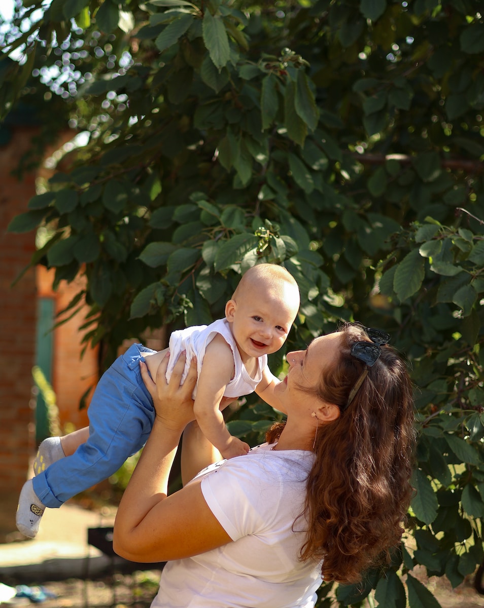 a woman holding a baby up in the air