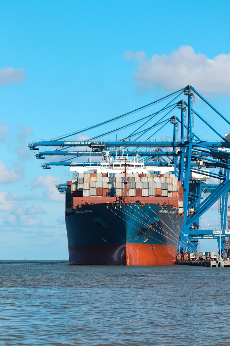 Photo by Nathan Cima a large cargo ship at a dock